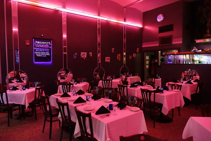 Dining room with set tables and red neon lights